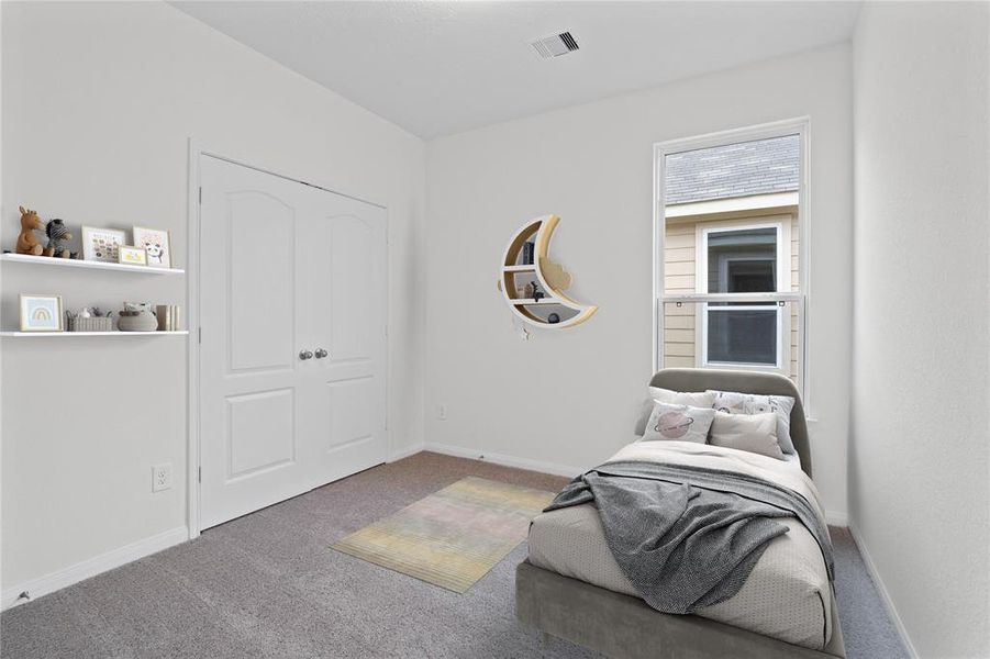 Secondary bedroom features plush carpet, custom paint, ample closet space, and a large window.