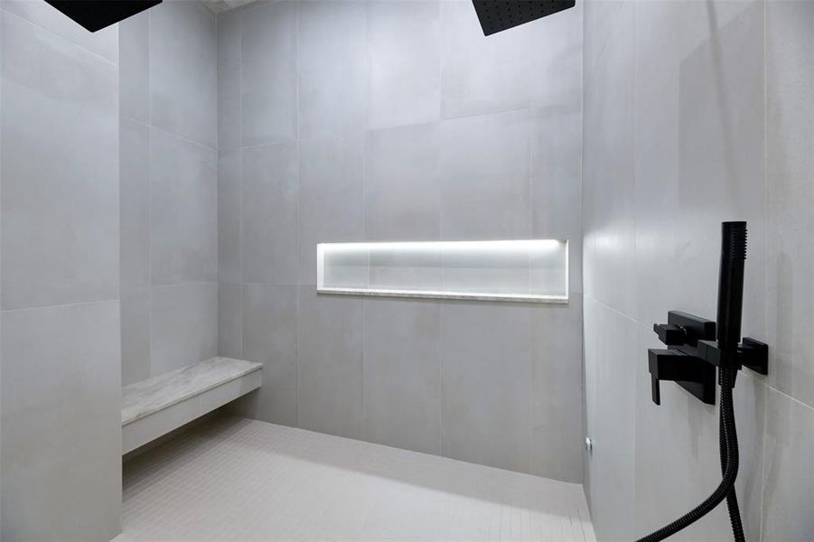 Full bathroom with a tile shower and tile walls