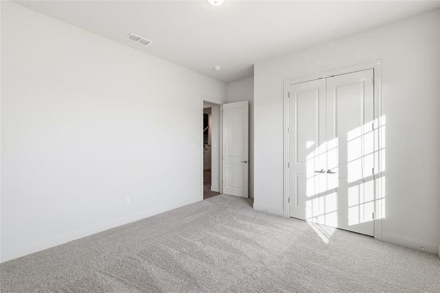 Unfurnished bedroom with carpet and a closet Unfurnished bedroom with carpet and a closet