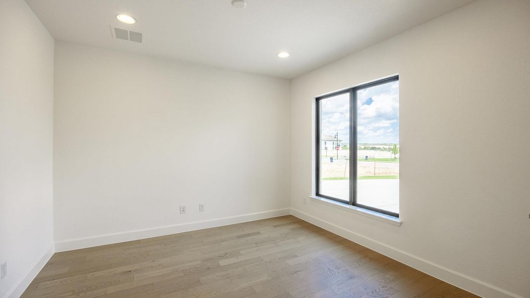 Empty room featuring wood finished floors and recessed lighting Empty room featuring wood finished floors and recessed lighting
