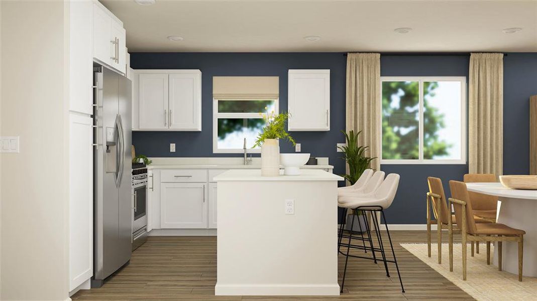 Kitchen featuring stainless steel appliances, a center island, a breakfast bar area, and white cabinetry Kitchen featuring stainless steel appliances, a center island, a breakfast bar area, and white cabinetry