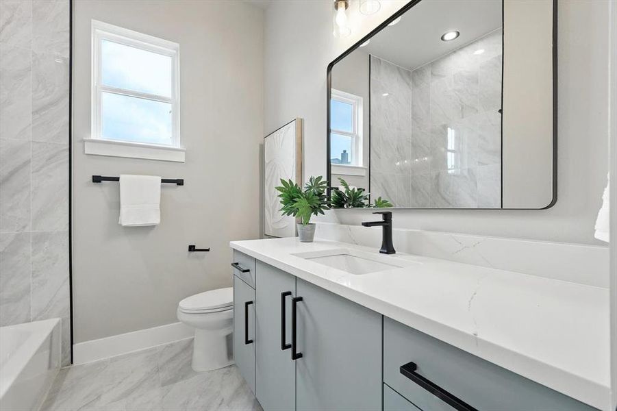 Full bathroom featuring vanity, marble finish flooring, and shower / washtub combination Full bathroom featuring vanity, marble finish flooring, and shower / washtub combination