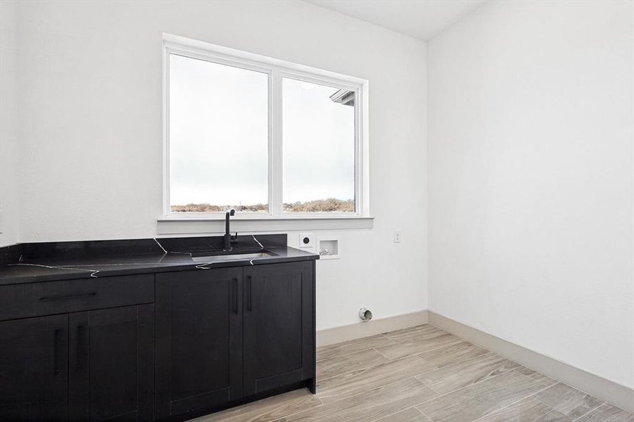 Washroom featuring hookup for an electric dryer, washer hookup, cabinets, and sink