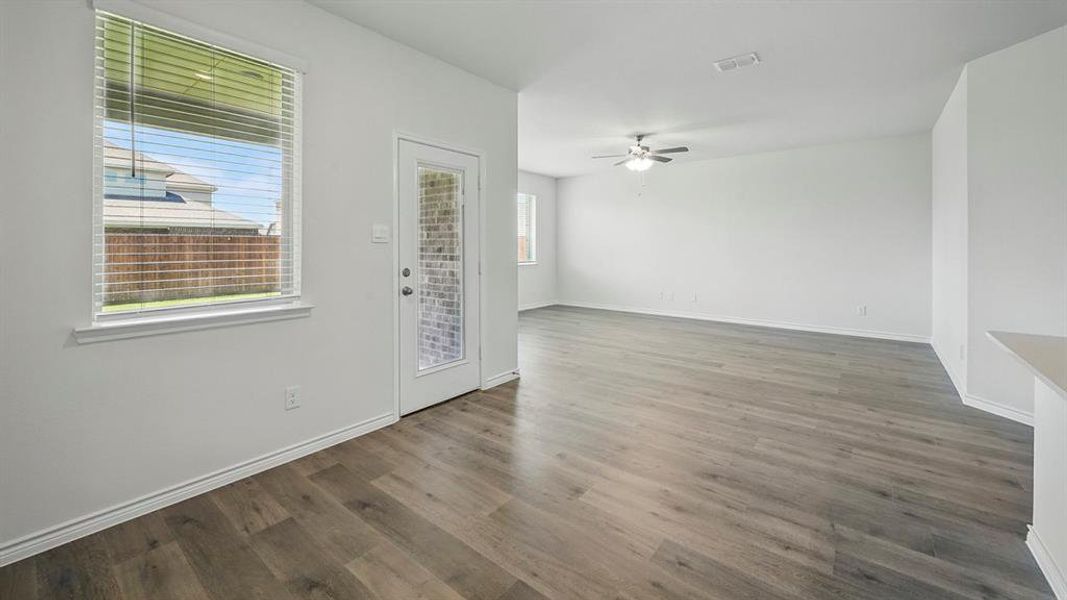 Spacious interior featuring wood-finish flooring, white walls, and a ceiling fan