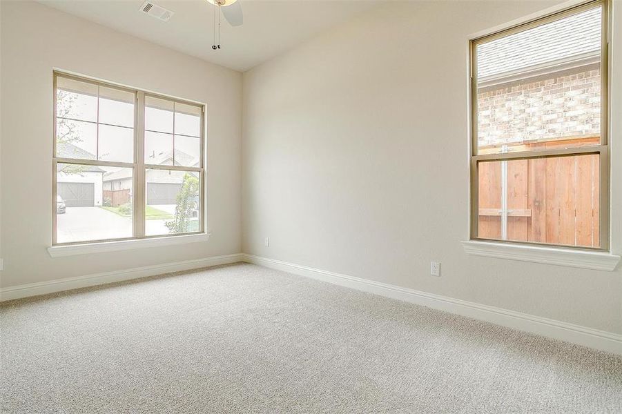 Carpeted empty room with ceiling fan