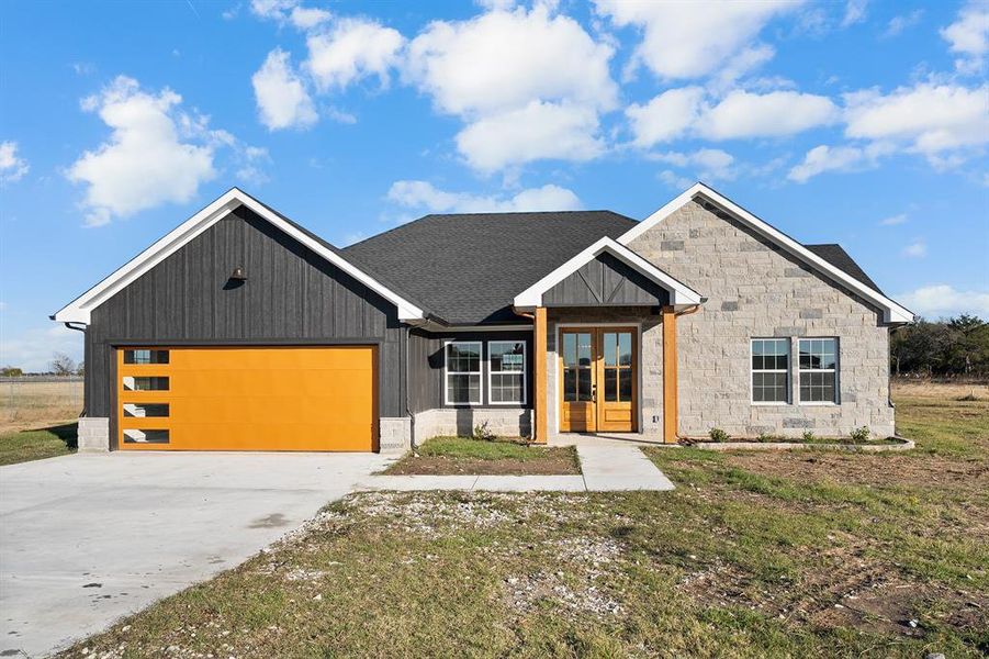 Modern farmhouse style home featuring french doors, driveway, a garage, a shingled roof, and a front yard