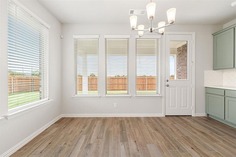 Unfurnished dining area with light wood-style flooring and a chandelier Unfurnished dining area with light wood-style flooring and a chandelier