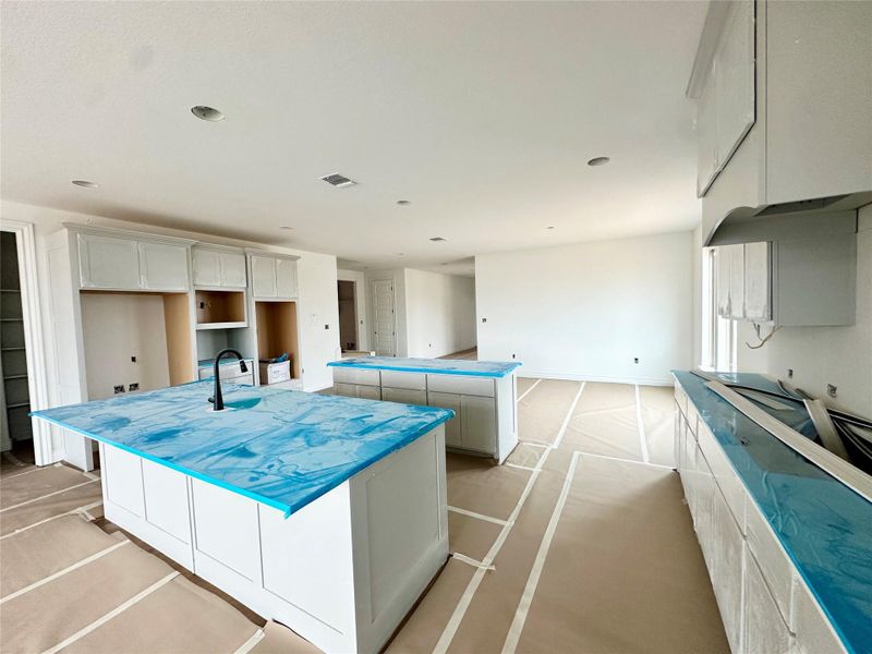 Kitchen with a kitchen island, a kitchen breakfast bar, and cooktop