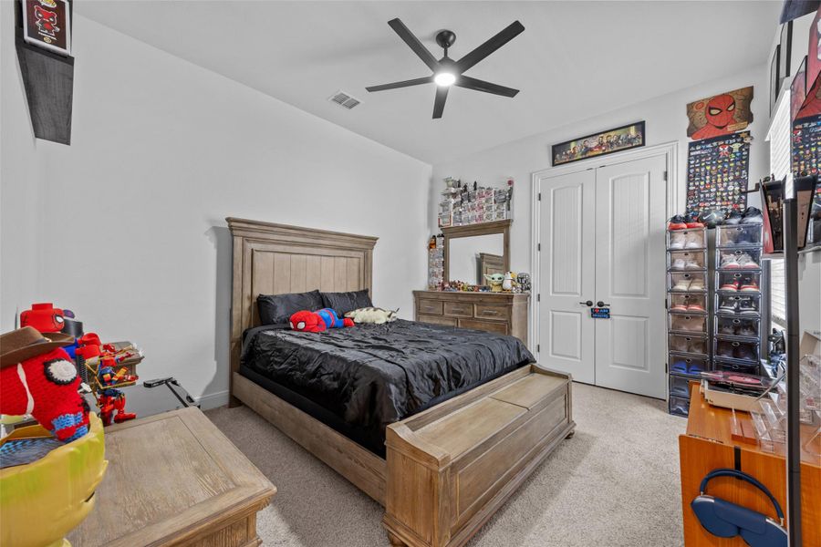 A well-lit bedroom with soft carpeting and a ceiling fan, offering a comfortable personal retreat. A well-lit bedroom with soft carpeting and a ceiling fan, offering a comfortable personal retreat.