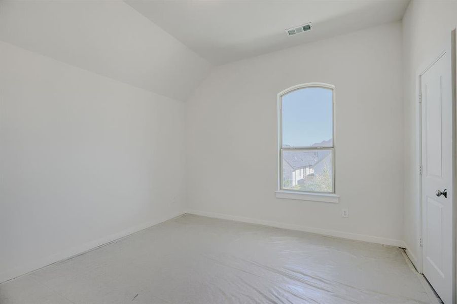 Vaulted ceiling room with an arched window and white trim