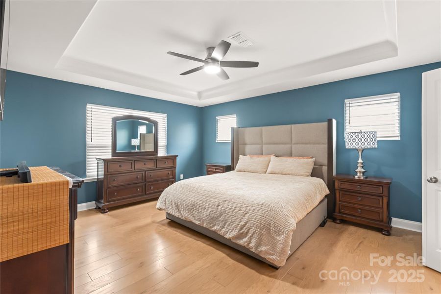 Large primary suite offers plenty of room and ambient light with treyed ceiling Large primary suite offers plenty of room and ambient light with treyed ceiling