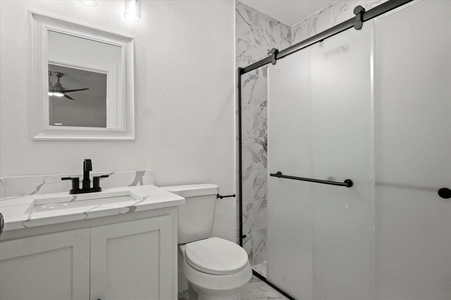 Bathroom featuring walk in shower, toilet, and vanity