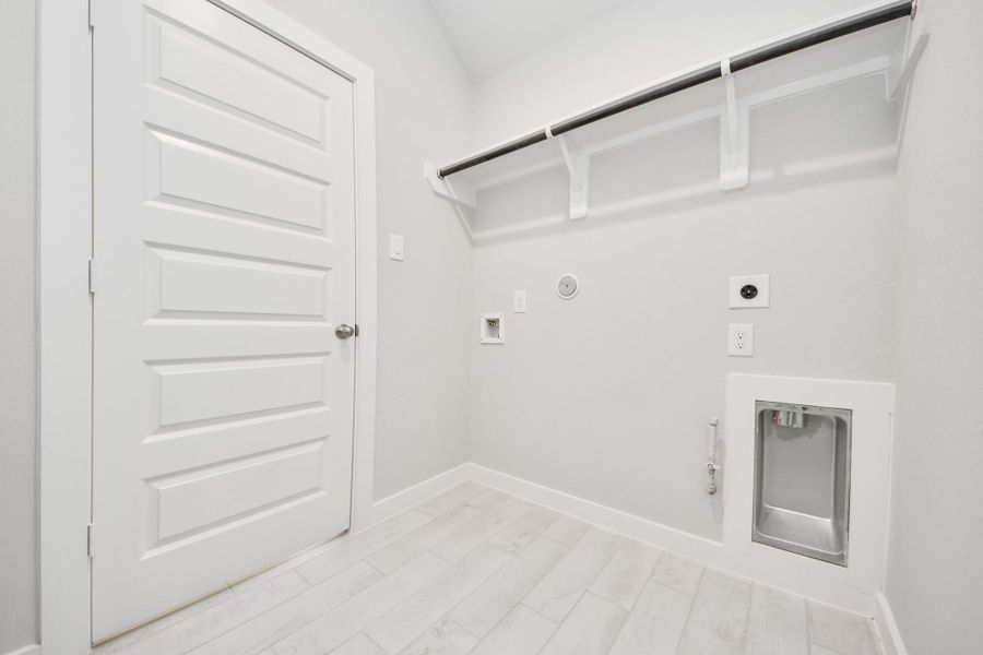 A perfect blend of functionality and comfort. Capture the essence of easy living with a first-floor laundry room, thoughtfully equipped with shelving for effortless organization. Both electric and gas connections available. Sample photo of completed home with similar floor plan. Actual colors and selections may vary. A perfect blend of functionality and comfort. Capture the essence of easy living with a first-floor laundry room, thoughtfully equipped with shelving for effortless organization. Both electric and gas connections available. Sample photo of completed home with similar floor plan. Actual colors and selections may vary.