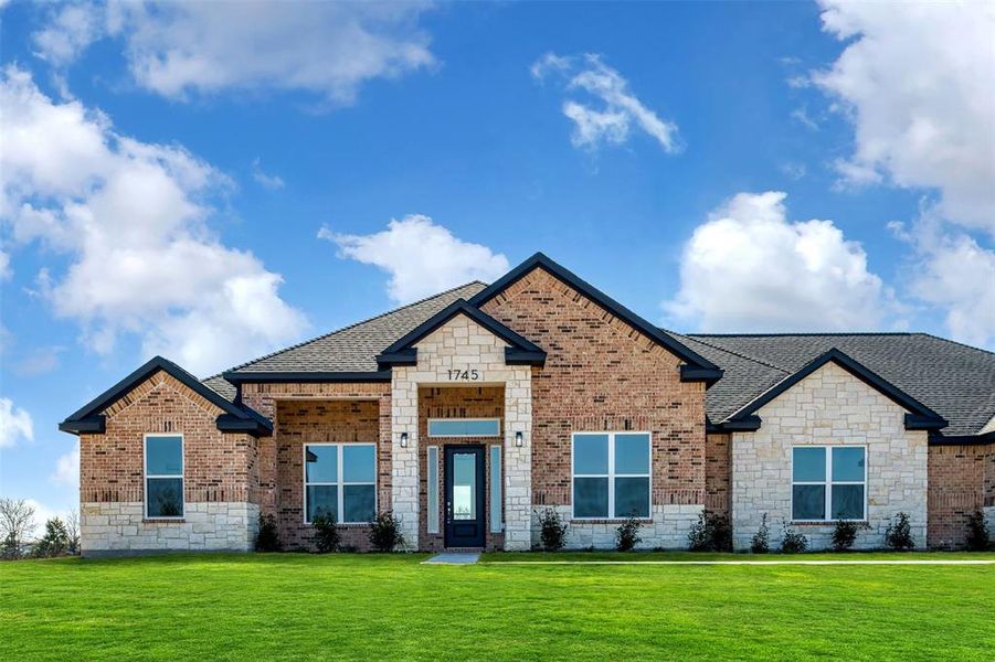 View of front of property featuring stone siding, a shingled roof, and a front lawn