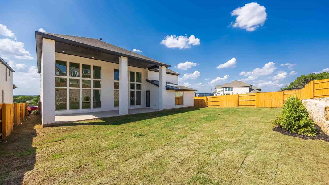 Rear view of house with a fenced backyard, a patio, and stucco siding