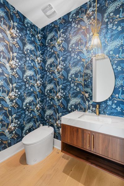 Bold botanical wallpaper and rich wood tones create a chic powder room retreat.