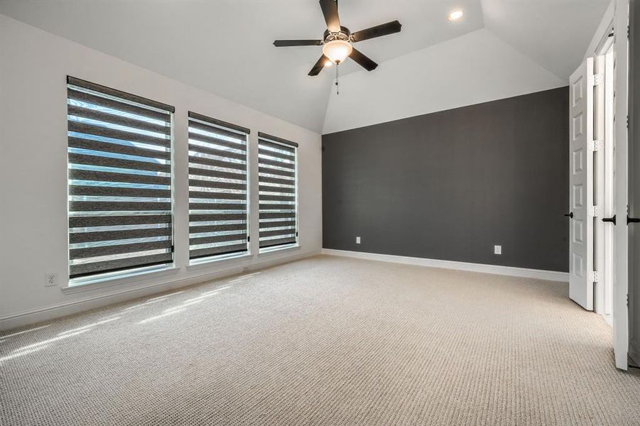 Unfurnished bedroom with baseboards, ceiling fan, carpet flooring, and vaulted ceiling