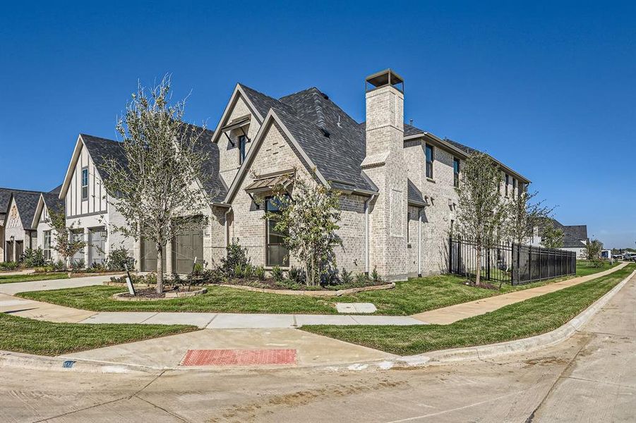 View of property exterior featuring a garage and a lawn