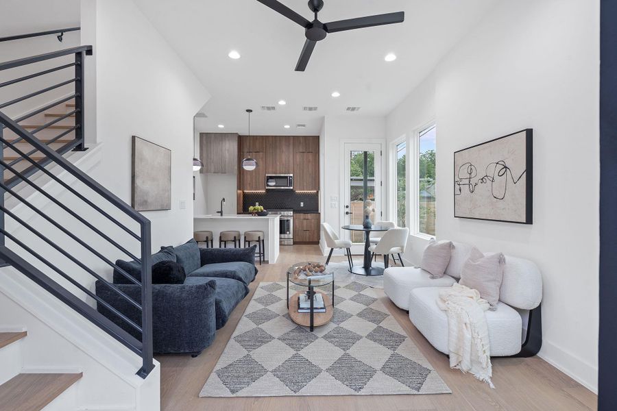 Living room featuring ceiling fan, recessed lighting, light wood-style flooring, and stairway