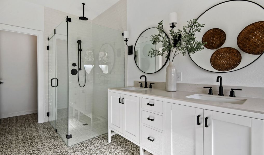 Primary bath with freestanding vanity and glass shower enclosure