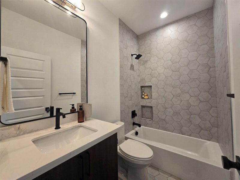 Hexagonal wall tile meets a modern stone vanity in this contemporary bathroom space.