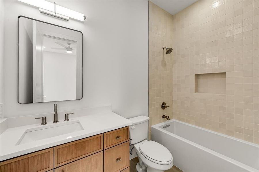 Bathroom featuring a single vanity with a rectangular undermount sink, a light-toned countertop, and wood-finish cabinetry
