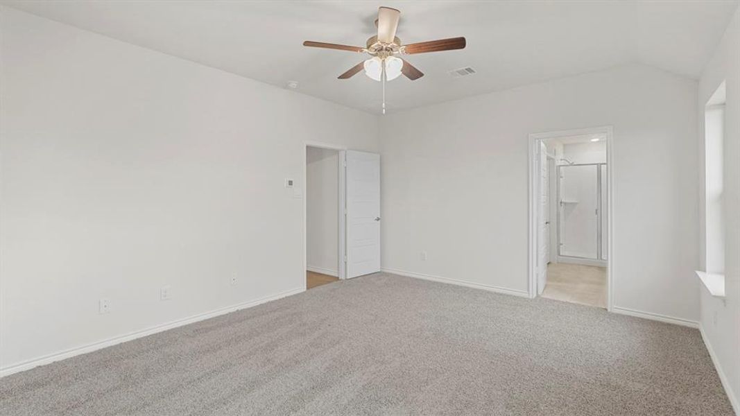 Spacious room featuring vaulted ceilings, light gray carpeting, and white painted walls