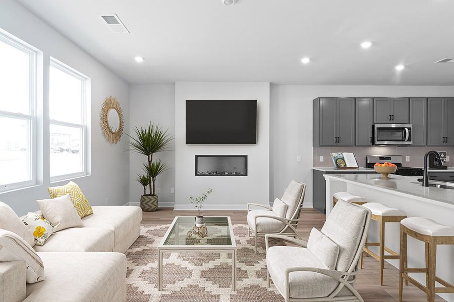 A living room with a tv and chairs. A living room with a tv and chairs.