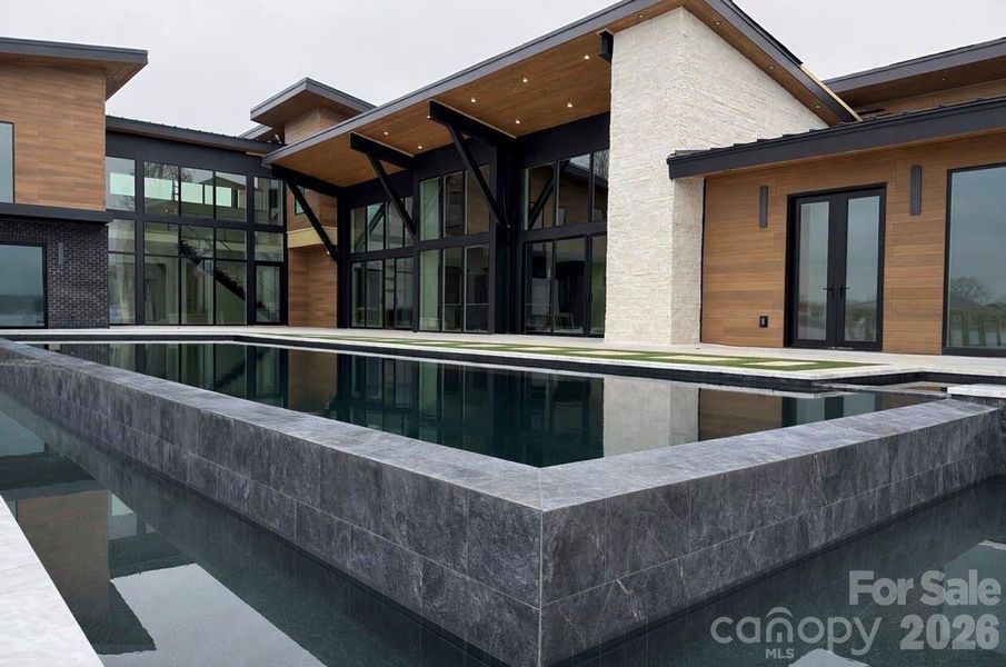 60’ Double Infinity Edge Saltwater Lap Pool w/ Cabo Shelf & Integrated Hot Tub- Accessible from Living Rooms, Kitchen, & Primary Suite