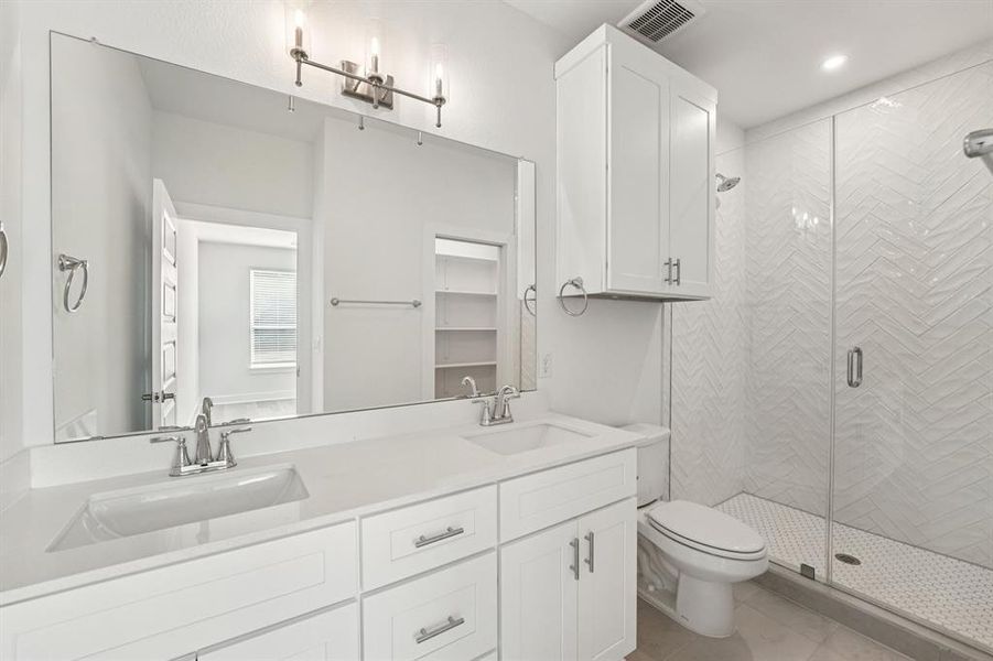 Fresh and bright, the primary bath features A dual quartz vanity and a walk-in shower with textured herringbone tile for a little extra style.(Sample photo of finishes and layout)