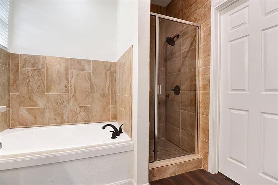 Bathroom featuring independent shower and bath and hardwood / wood-style floors