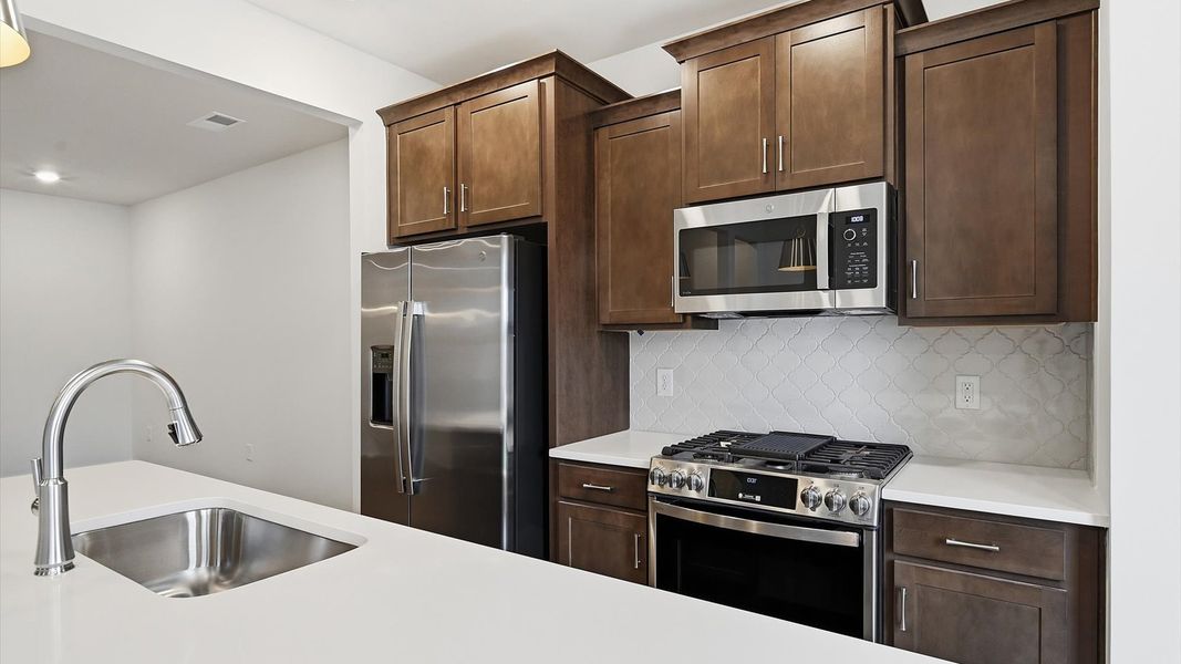 Exclusive kitchen design with large island, pendant lights, and tasteful finishes throughout at the Saluda Crossing community Exclusive kitchen design with large island, pendant lights, and tasteful finishes throughout at the Saluda Crossing community
