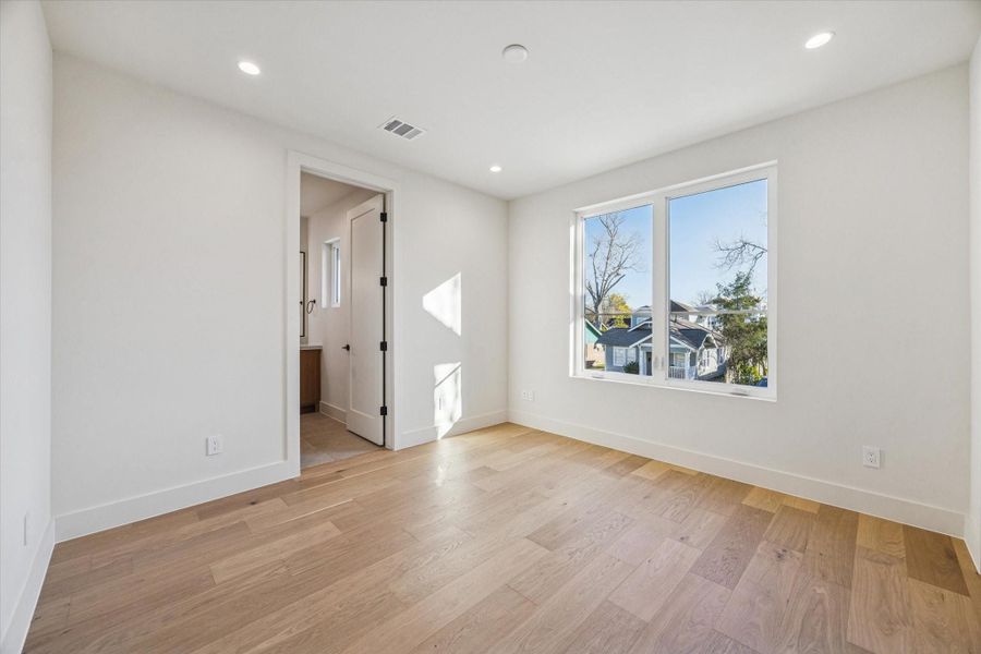 Secondary bedroom with a walk-in closet with built-ins and an ensuite full bathroom.