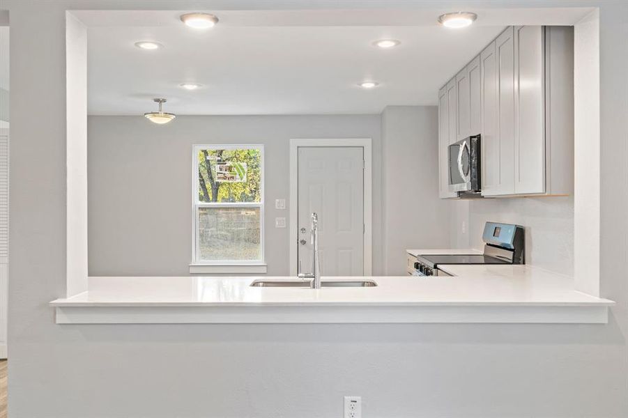 Kitchen with kitchen peninsula, stainless steel appliances, and sink