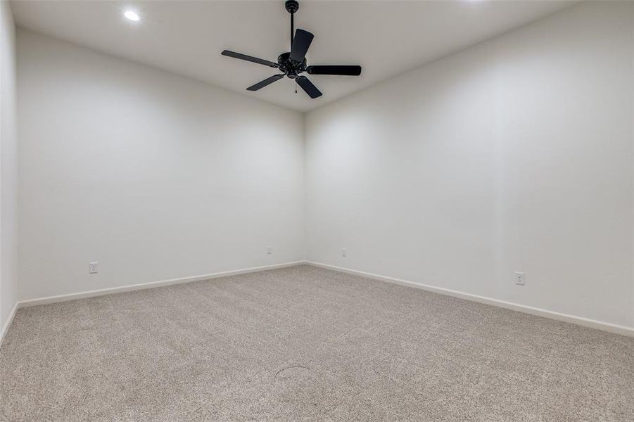 Carpeted spare room with ceiling fan