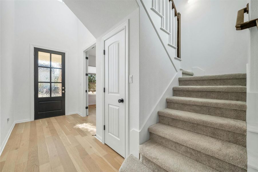 The welcoming entry foyer sits under soaring high ceilings and is open to the second floor hallway above.