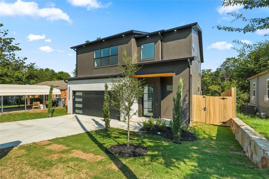 Contemporary house with an attached garage, concrete driveway, stucco siding, and a gate