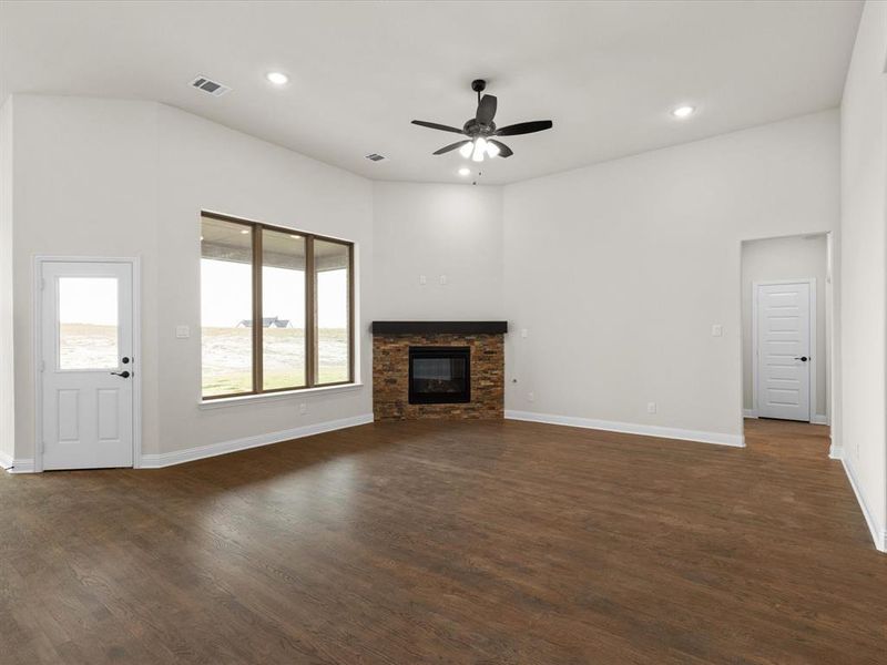 Unfurnished living room featuring a glass covered fireplace, dark wood finished floors, a ceiling fan, and recessed lighting