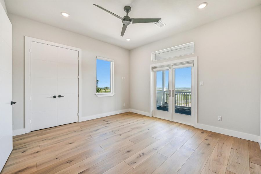 This versatile bedroom features porch access, white oak flooring, and abundant natural light. Whether used as a guest suite, office, or private retreat, the space feels bright and inviting.