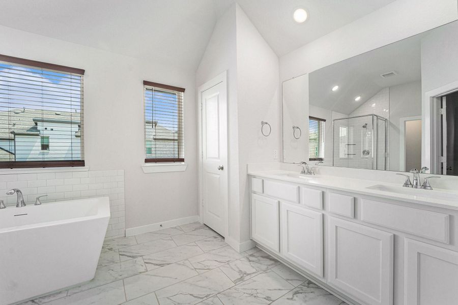 Spa-inspired primary bath with dual sinks, quartz counters, and modern finishes.