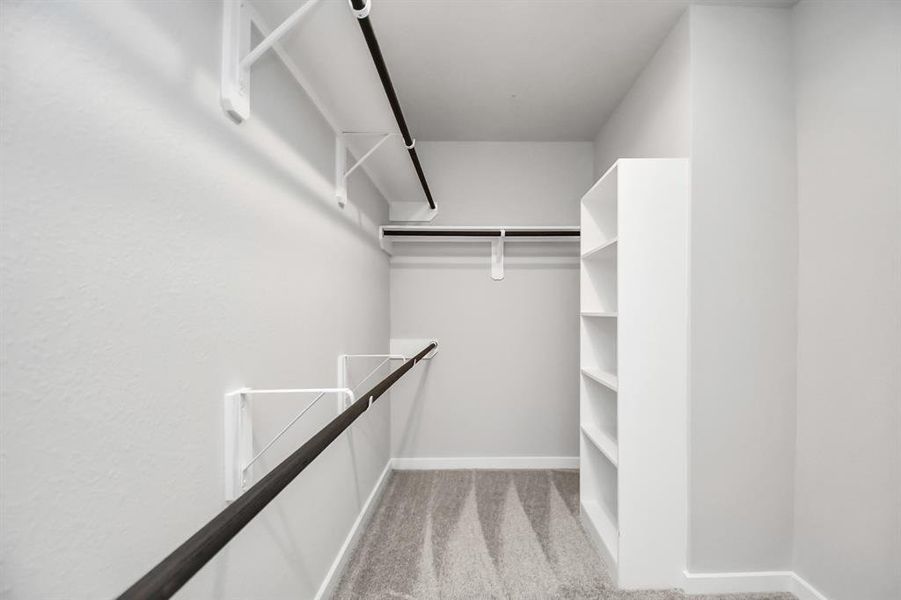 Walk-in closet that epitomizes luxury and practicality. This generously sized space features built-in shelving, offering abundant room for impeccable organization. High ceilings and recessed lighting create a bright and welcoming ambiance.