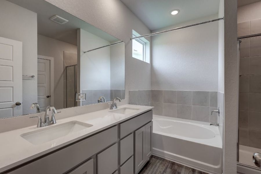 A bathroom with a tub sink and mirror. A bathroom with a tub sink and mirror.