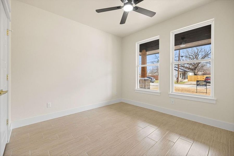 Empty room featuring baseboards, ceiling fan, and light wood finished floors