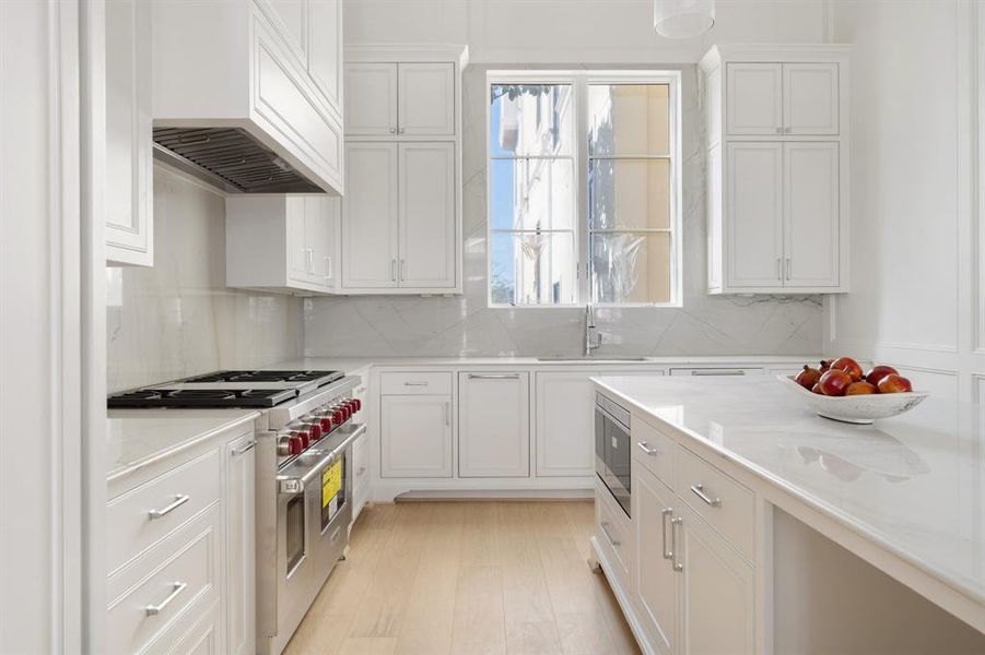 An abundance of natural light pours through expansive windows into this open kitchen enhanced by designer touches and rich architectural elements that elevate everyday living. (photo of interior model home with smaller floor plan)