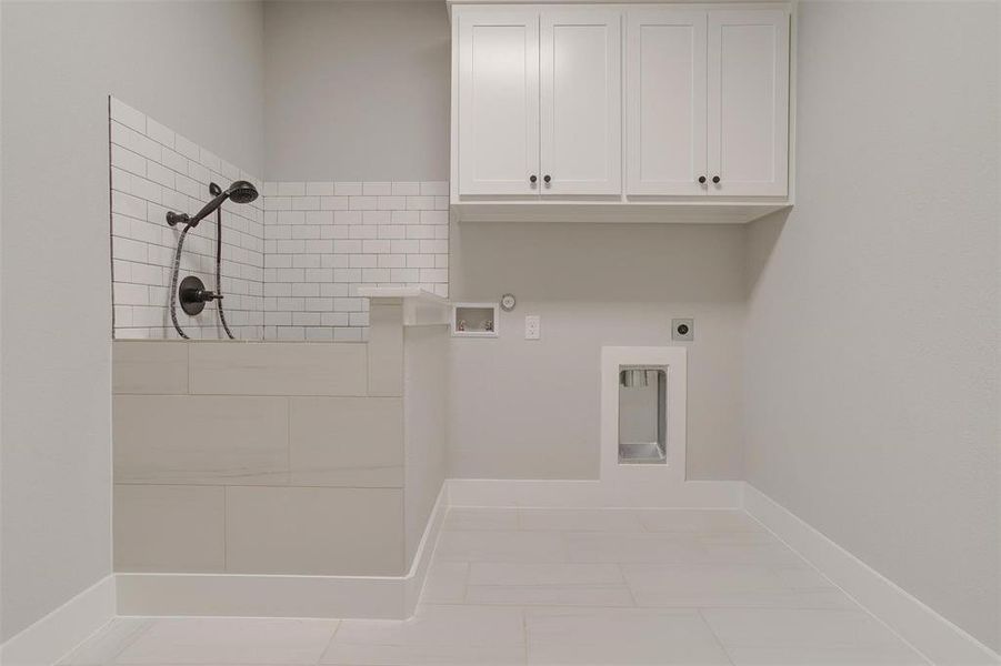 Clothes washing area featuring cabinets, washer hookup, electric dryer hookup, hookup for a gas dryer, and light tile patterned flooring