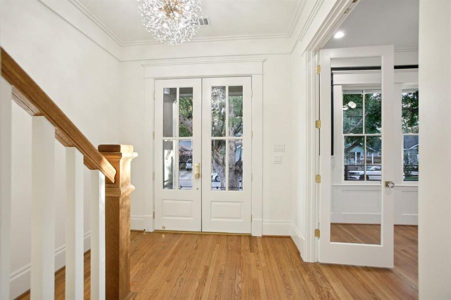 The wide front entry hall welcomes you with a pretty ornamental light and a view to the study (behind doors).