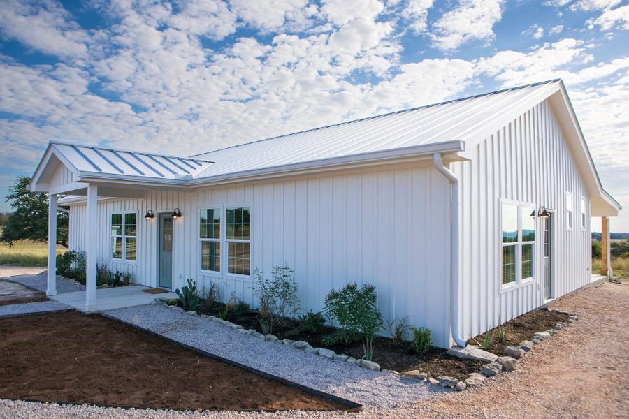 View of front facade featuring a metal roof, board and batten siding, and a standing seam roof View of front facade featuring a metal roof, board and batten siding, and a standing seam roof