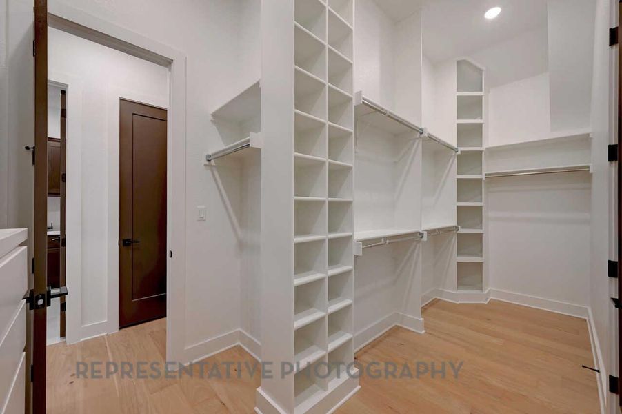 Walk in closet with light wood-style floors Walk in closet with light wood-style floors