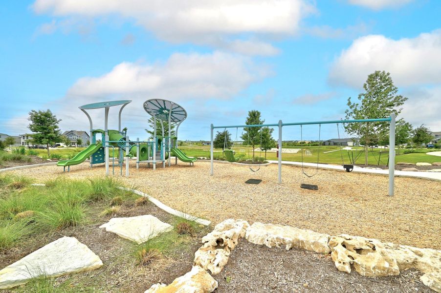 Neighborhood playground featuring modern play structures, swing sets, and shade canopy sails. Neighborhood playground featuring modern play structures, swing sets, and shade canopy sails.