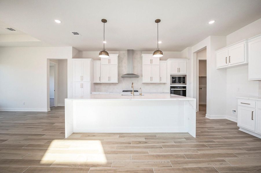 The chef-inspired island kitchen flows seamlessly into the family room, creating the ideal space for entertaining.